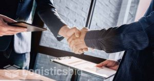 Dua profesional berjabat tangan, simbolisasi pembentukan hubungan pelanggan yang sukses.