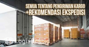 Truk kargo dan tumpukan barang siap kirim di gudang.